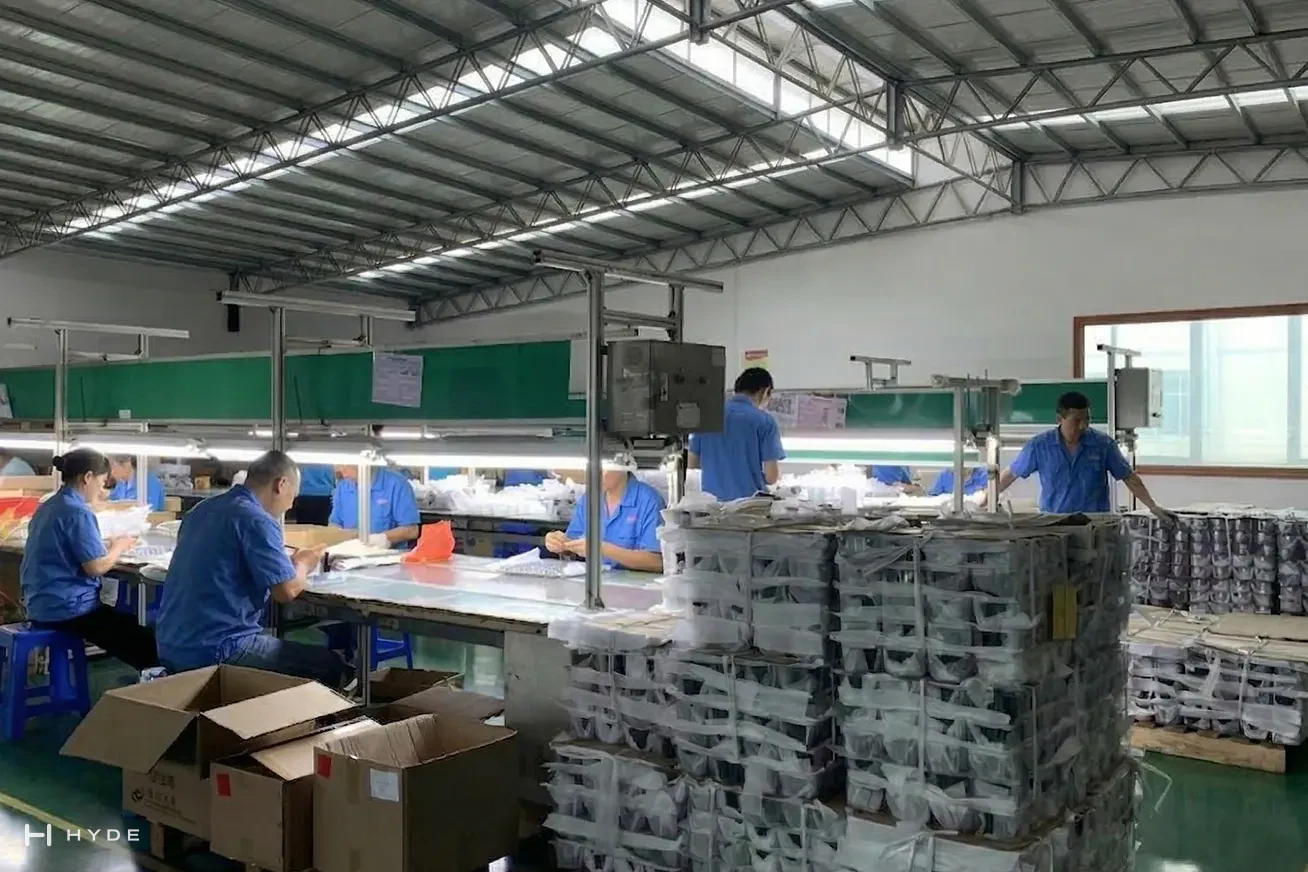 Our assembly hall: operators building and bagging sets at the benches, with finished goods palletised behind them